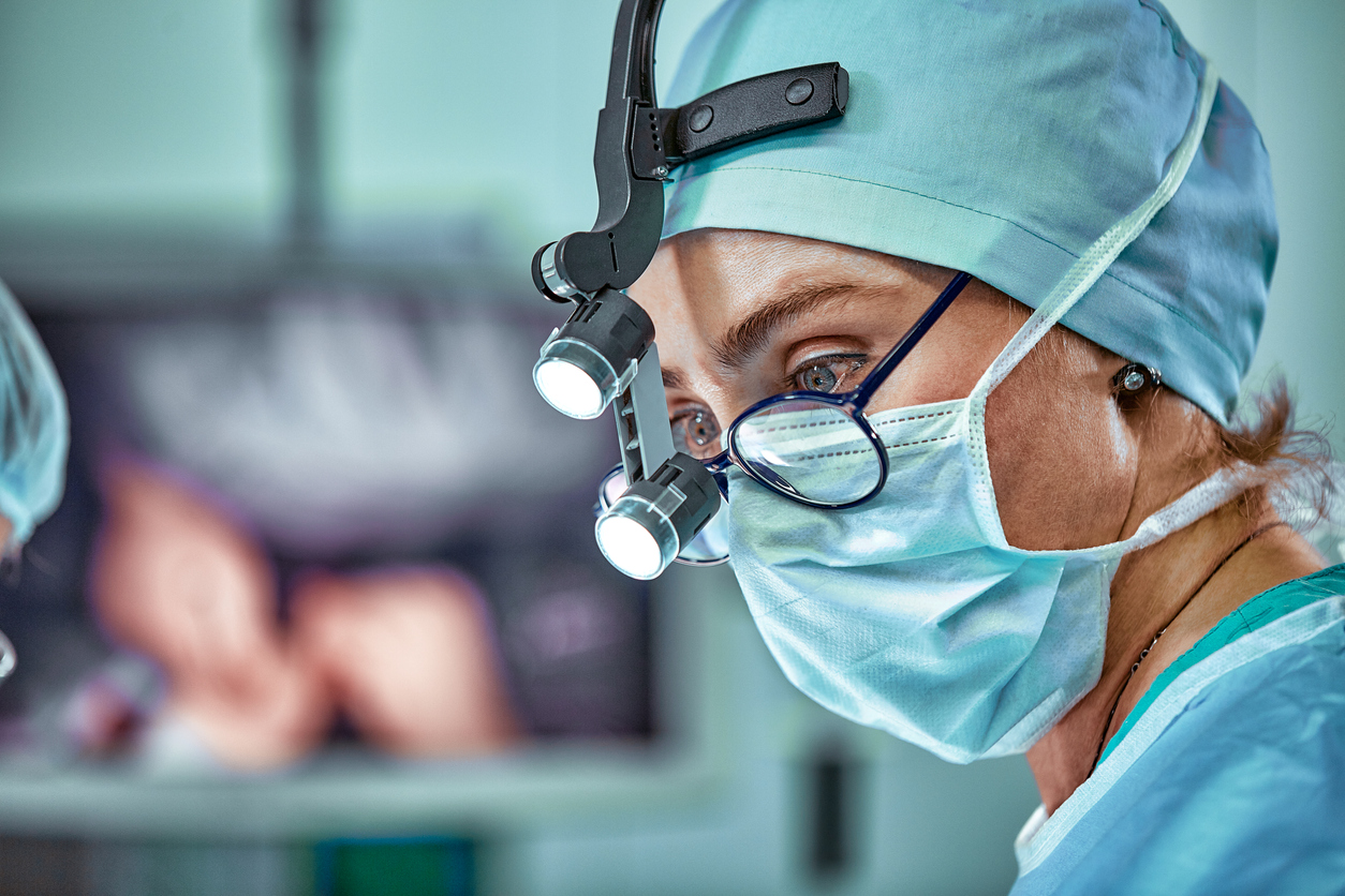 Female surgeon in operating room wearing mask and glasses