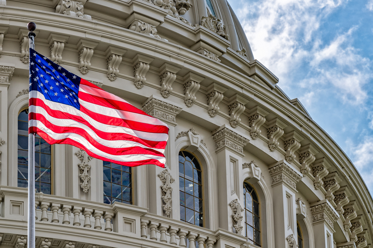 American flag next to Washington DC Capitol dome