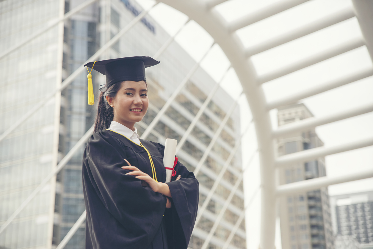 Female MBA graduate holding diploma