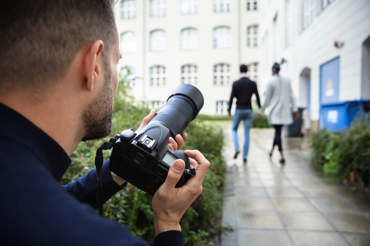 Private investigator taking a photograph of a couple