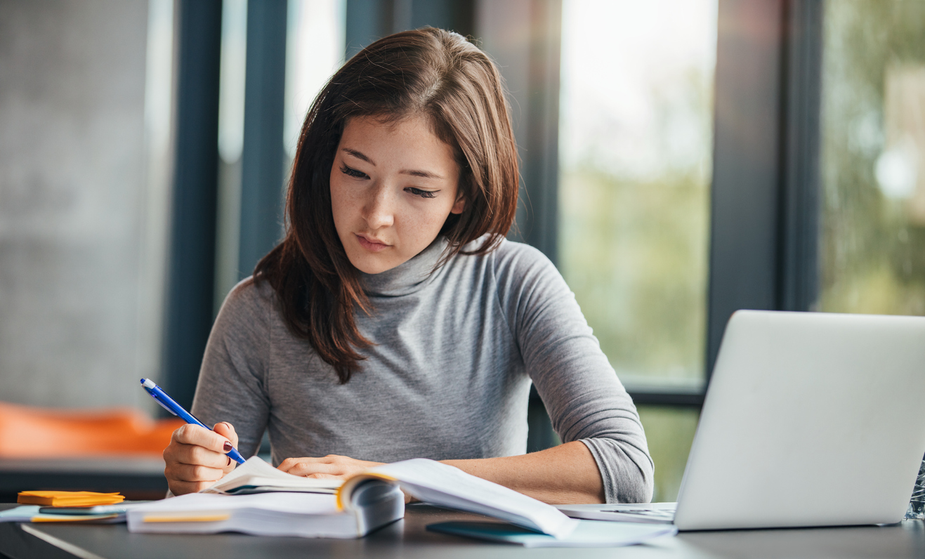 Young woman writing an investment plan