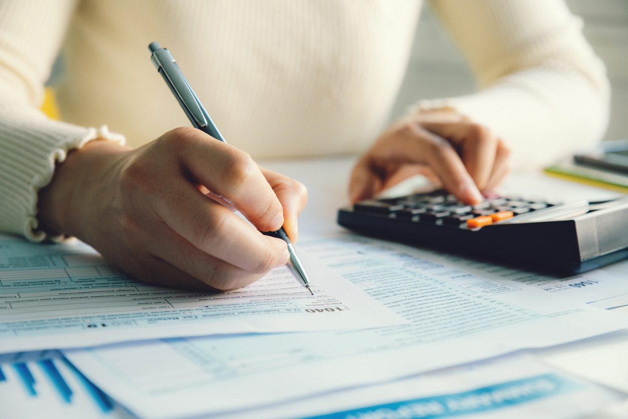 Woman with calculator filling out tax return