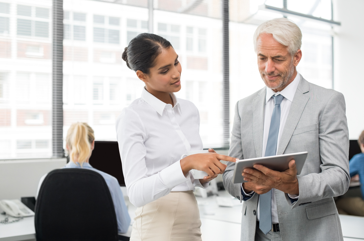 Young businesswoman helping CFO with tablet