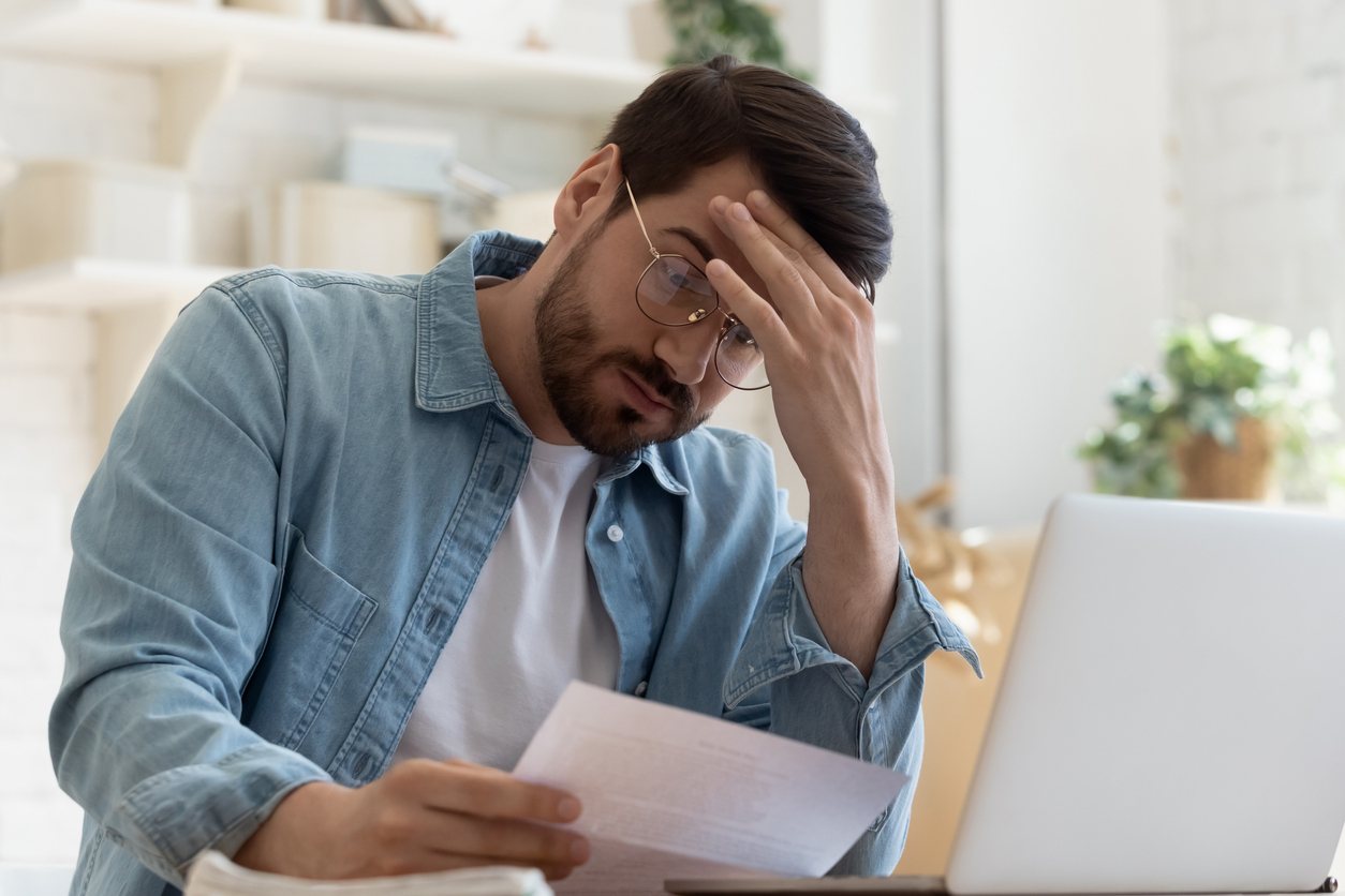 Man reading a letter about a rejected insurance claim