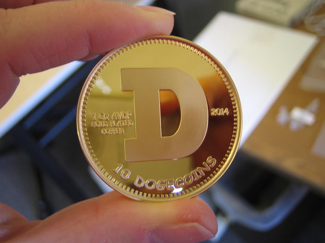 Man holding physical gold-plated dogecoin