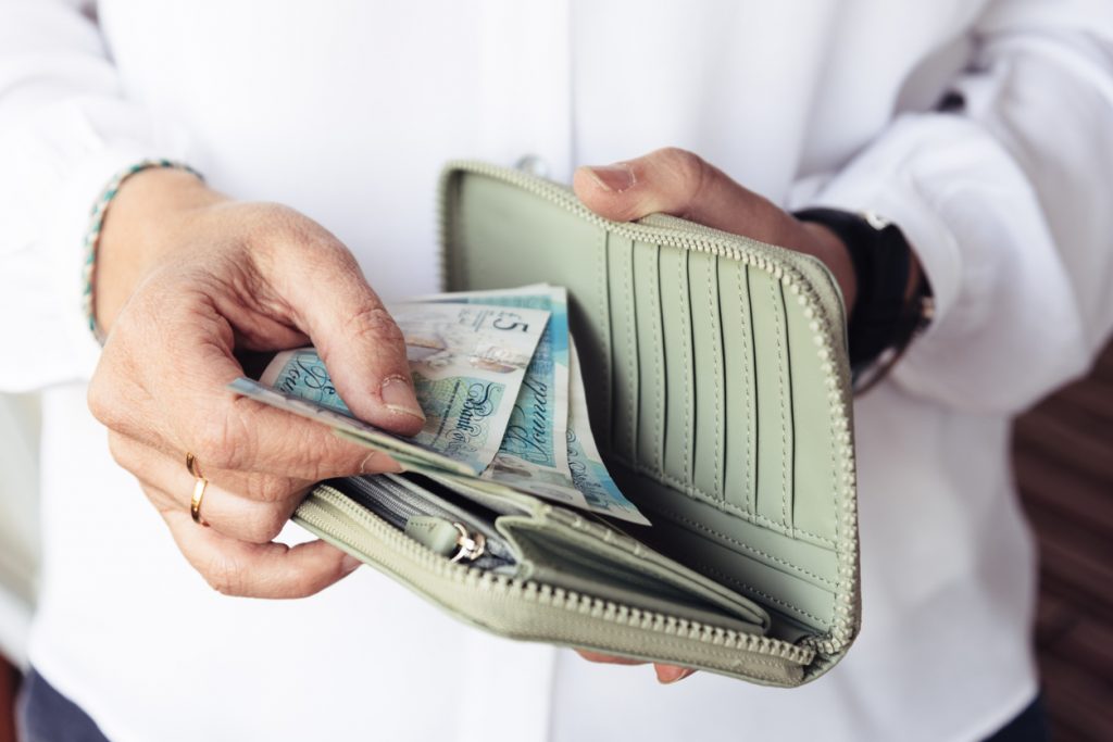 Woman taking pound notes from her purse