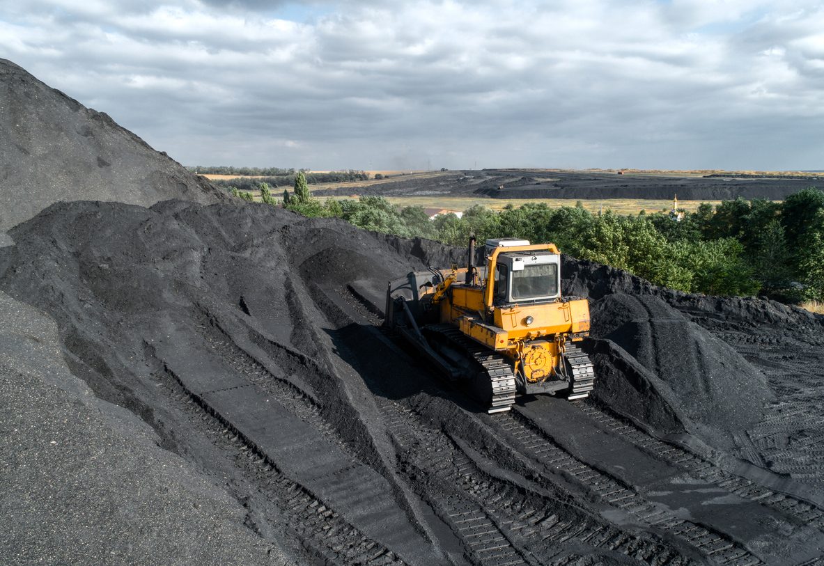 Bulldozer pushing hard coal pile