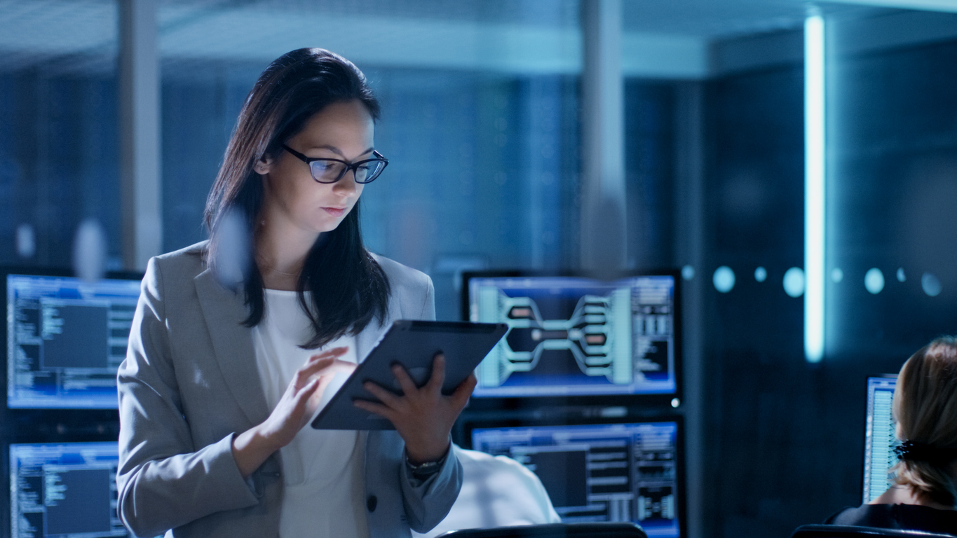 Female IT technician looking at a tablet in a server room