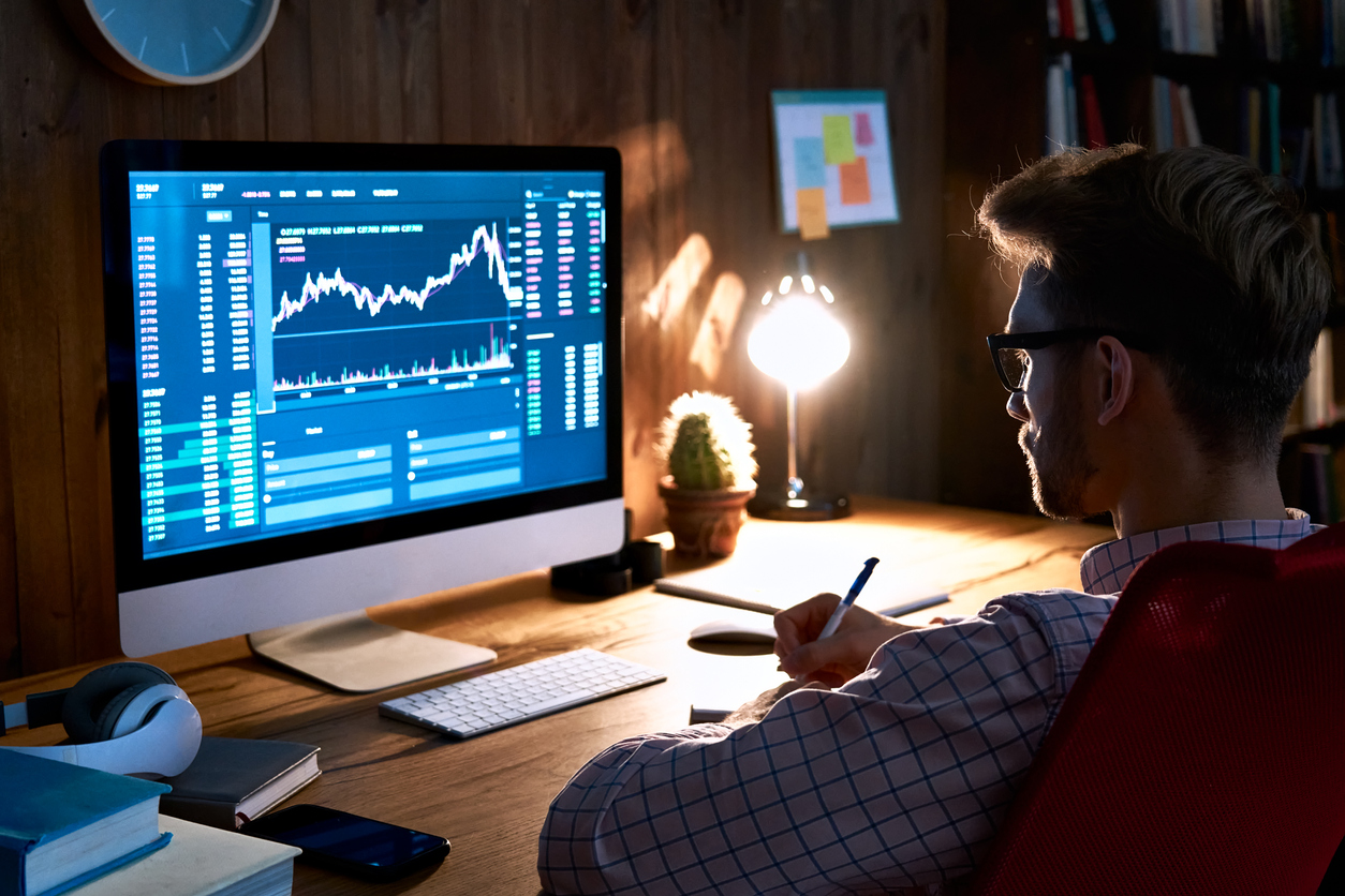 Crypto trader looking at computer monitor in study