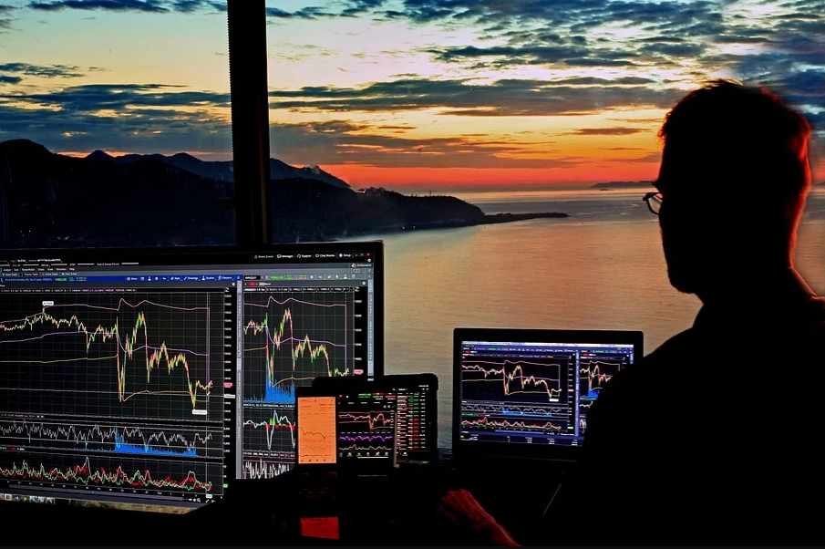 Silhouette of man looking at stock graphs