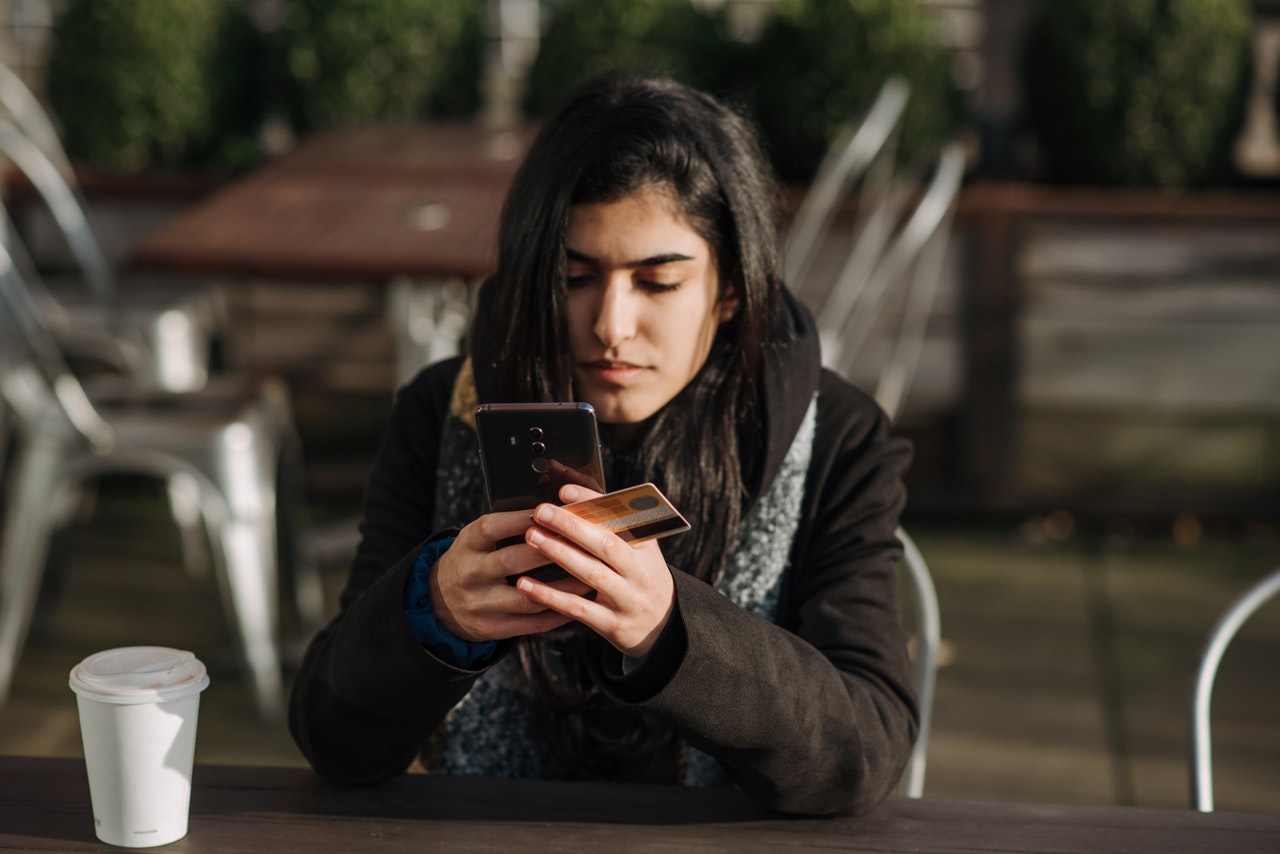 Woman making payment via smart phone