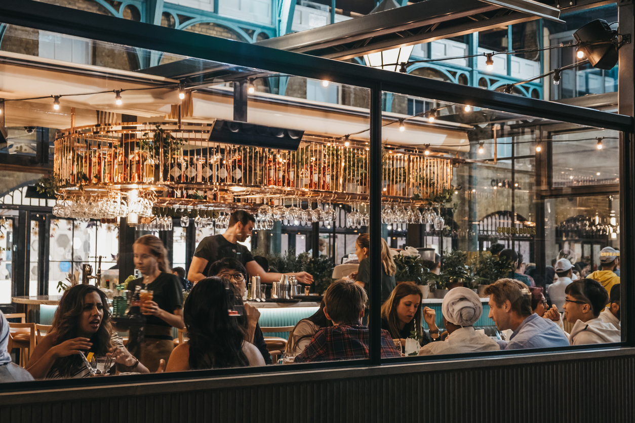 View through the window of busy restaurant in Covent Garden Market, London, UK.