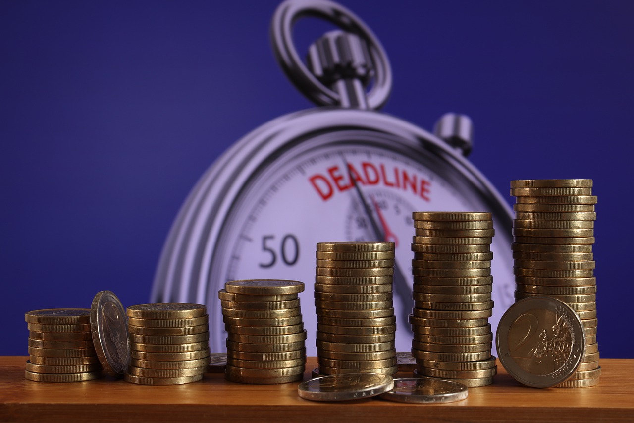 Deadline for debt; stacks of coins by stop watch