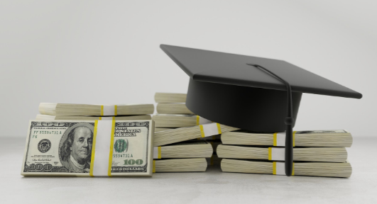 Graduation cap on stacks of cash