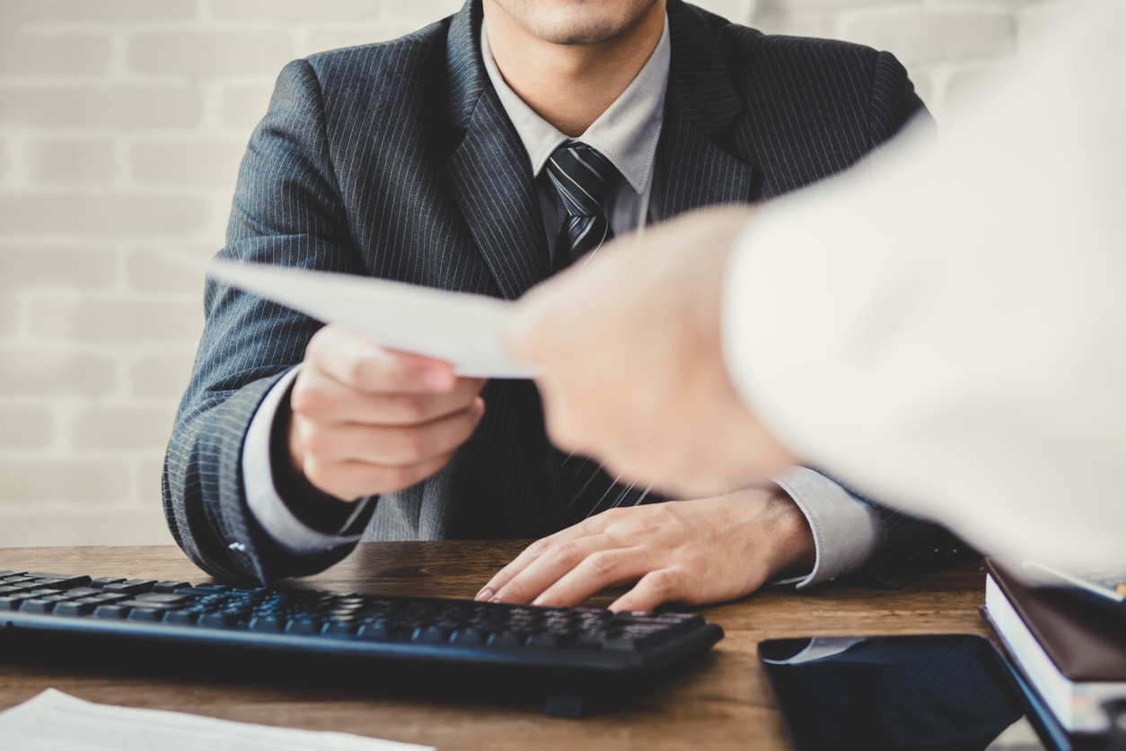 Employee handing resignation letter to boss