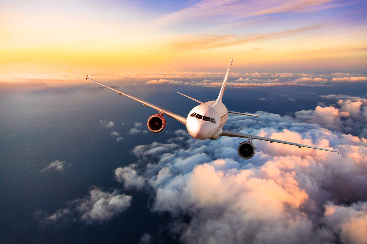 Passengers commercial airplane flying above clouds, front view. Concept of fast modern travel