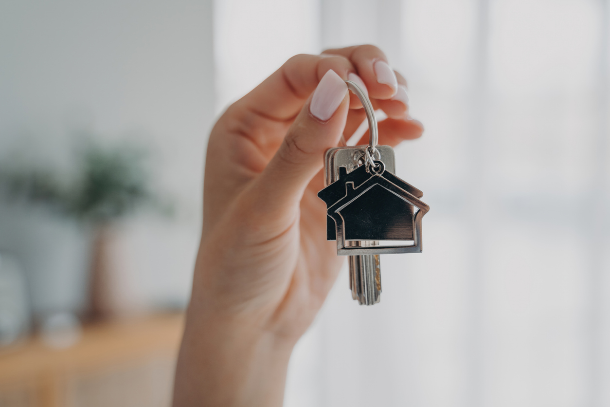 Key to new house. Close-up of female hand hold bunch of keys. Woman real estate agent real estate agent makes offer, showing key from new home apartment. Purchase of housing, copy space.