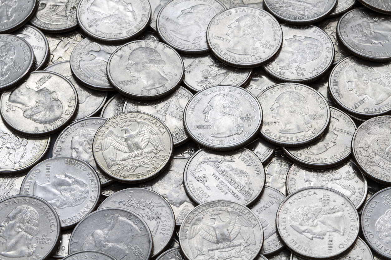 A close up shot of a pile of various used modern clad (non-silver, Cupronickel) USA Washington Quarters.