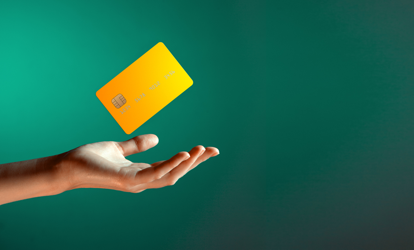 close up female hand holds levitating template mockup bank credit card with online service isolated on green background