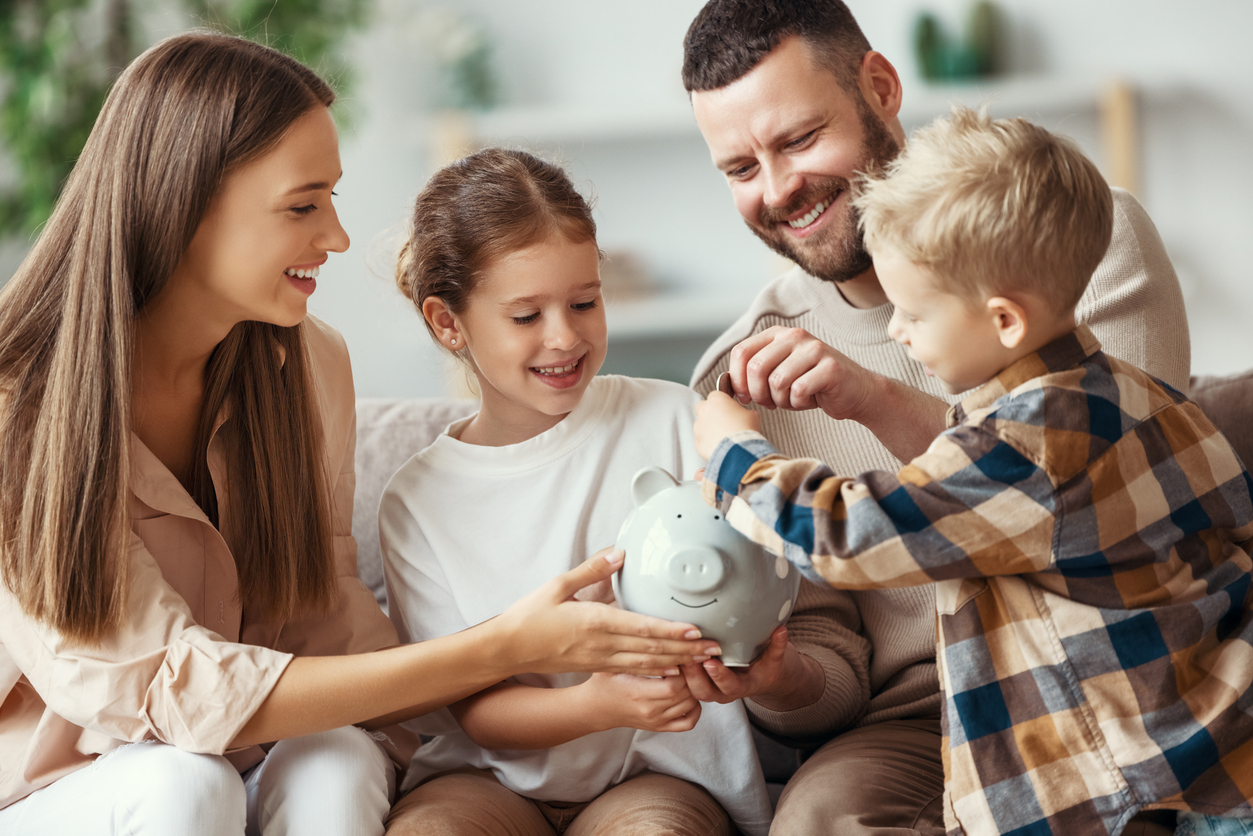 financial planning family mother father and children with piggy bank at home