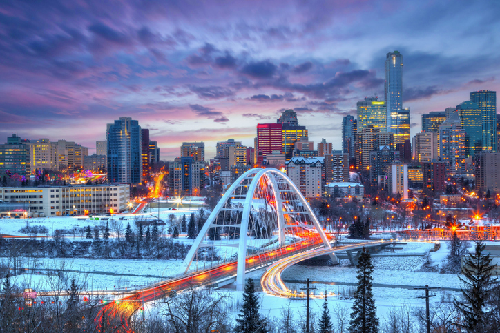 light trails from rush hour traffic light up walterdale bridge in edmonton, canada, on a sunset winter night