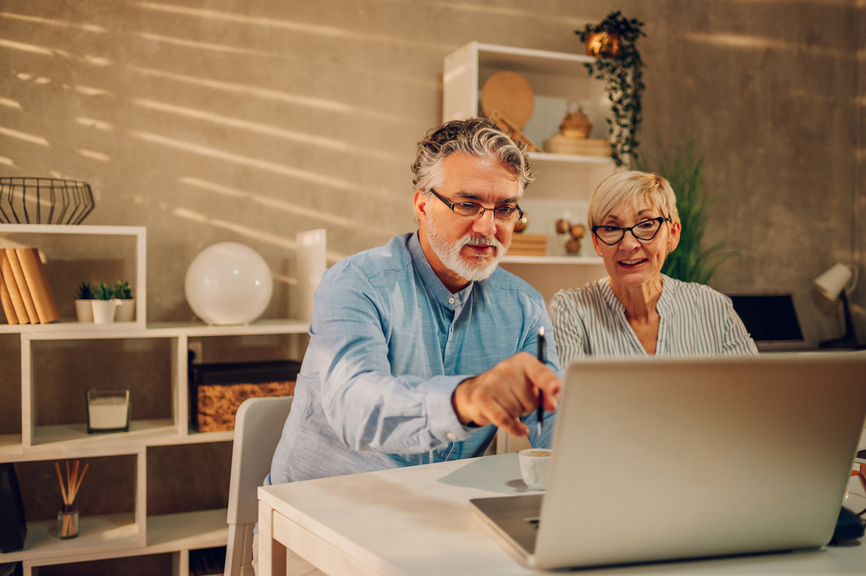 senior couple online shopping with a laptop at home