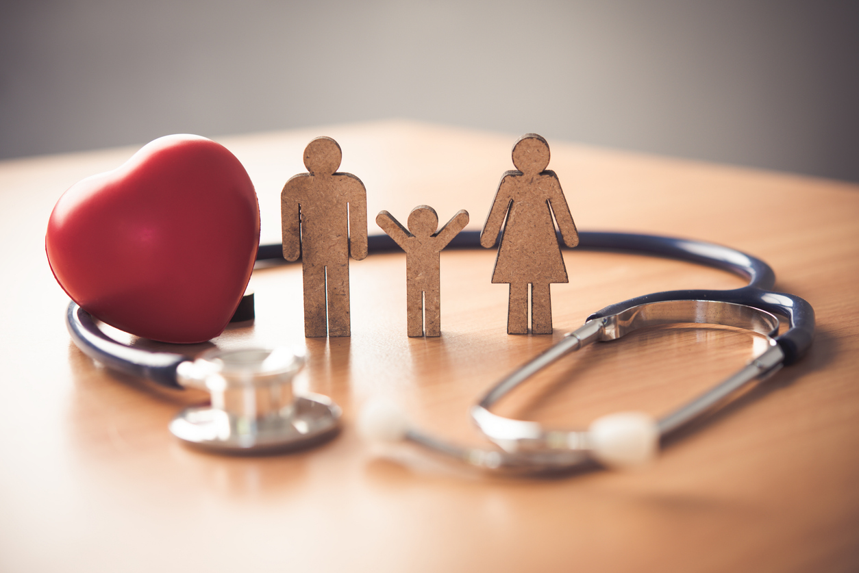 medical insurance concept with family and stethoscope on wooden desk