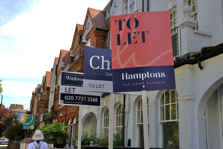 real estate agent "to let " signs in front of terrace house in london.