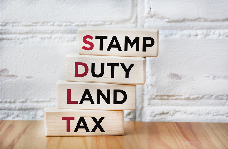 sdlt stamp duty, land tax written on blocks on an office desk.