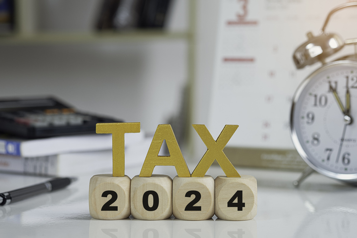 tax and vat 2024 concept.tax wooden letters on wooden cubes with 2024 on coins. income tax online return form for payment. expenses, account, vat, pay tax in 2024 year.