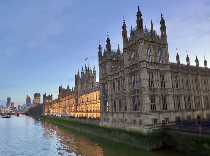 the houses of parliament, officially known as the palace of westminster, on the river thames illuminated at dusk in westminster, london, england.