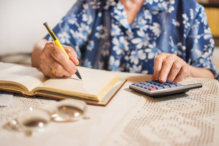 close up of unrecognizable senior woman doing finances at home.