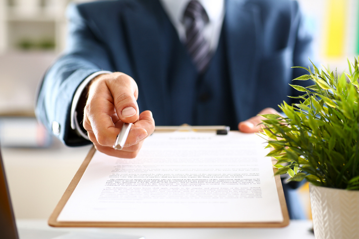 male arm in suit offer contract form on clipboard