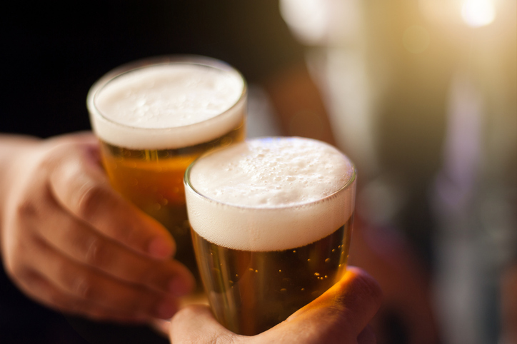 cheers! clink glasses. close up shots of hands holding beer glasses and beer bubbles.