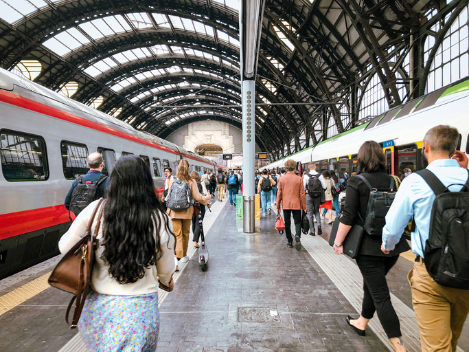 train station, rush hour. people and commuters walking on the platform. milan central station, italy