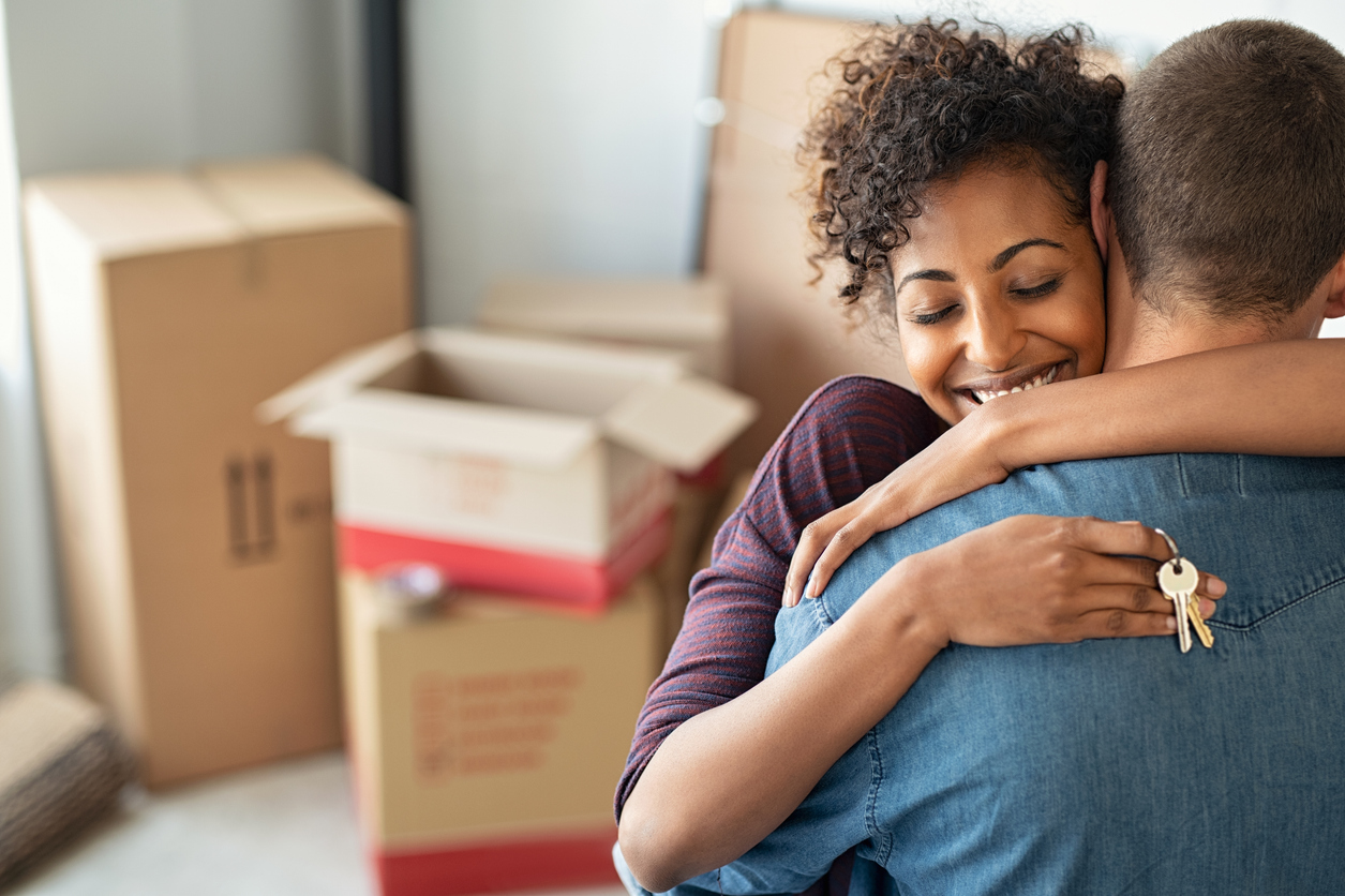 woman hugging man and holding home keys