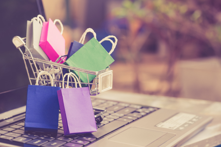 shopping bags and a shopping cart on a laptop keyboard