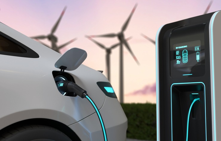 electric cars charging at the charging station and with a wind turbine background, electric power is an alternative fuel