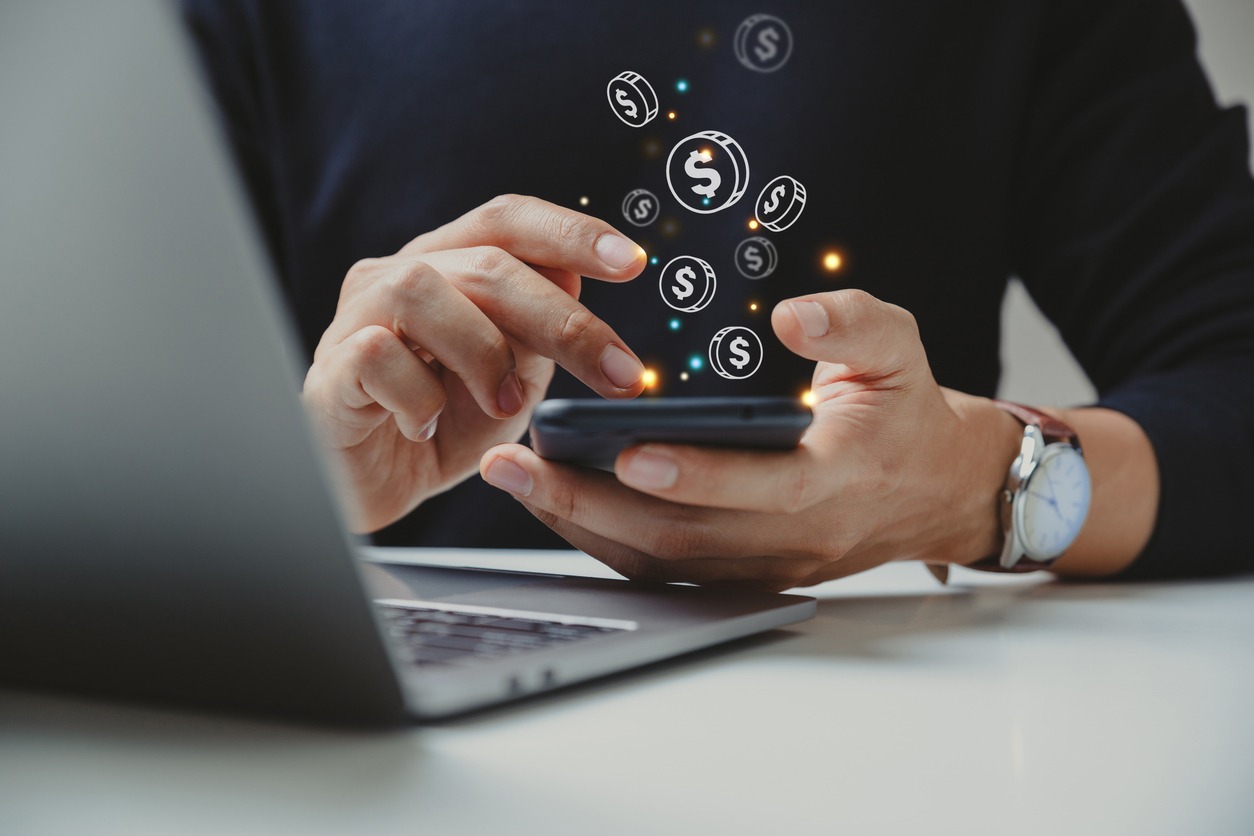 hand of businessman using smart phone with coin icon.