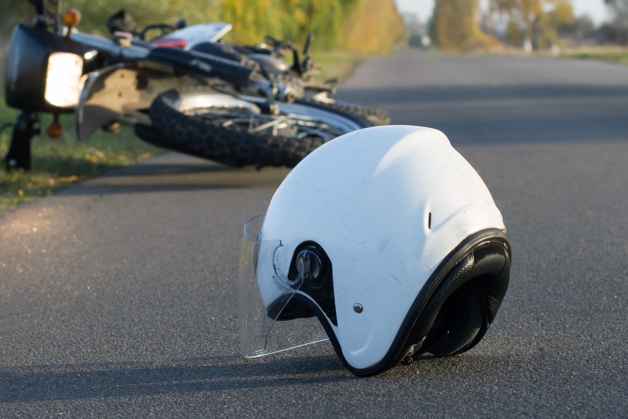 photo of helmet and motorcycle on the road, the concept of road accidents