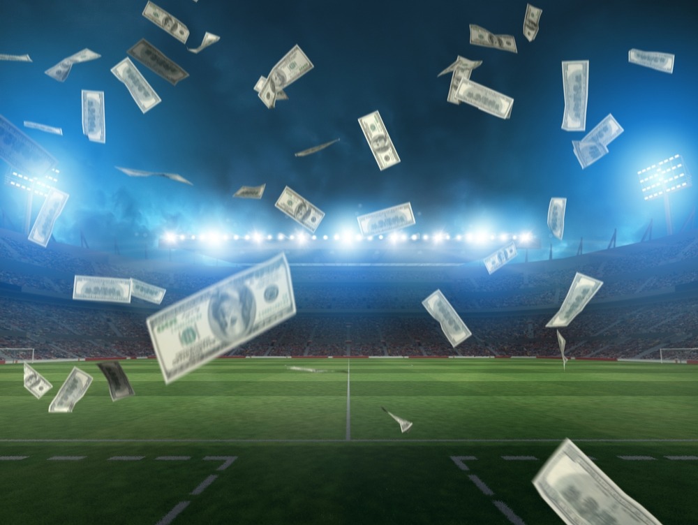 illuminated,soccer,stadium,and,falling,banknotes,of,bettors