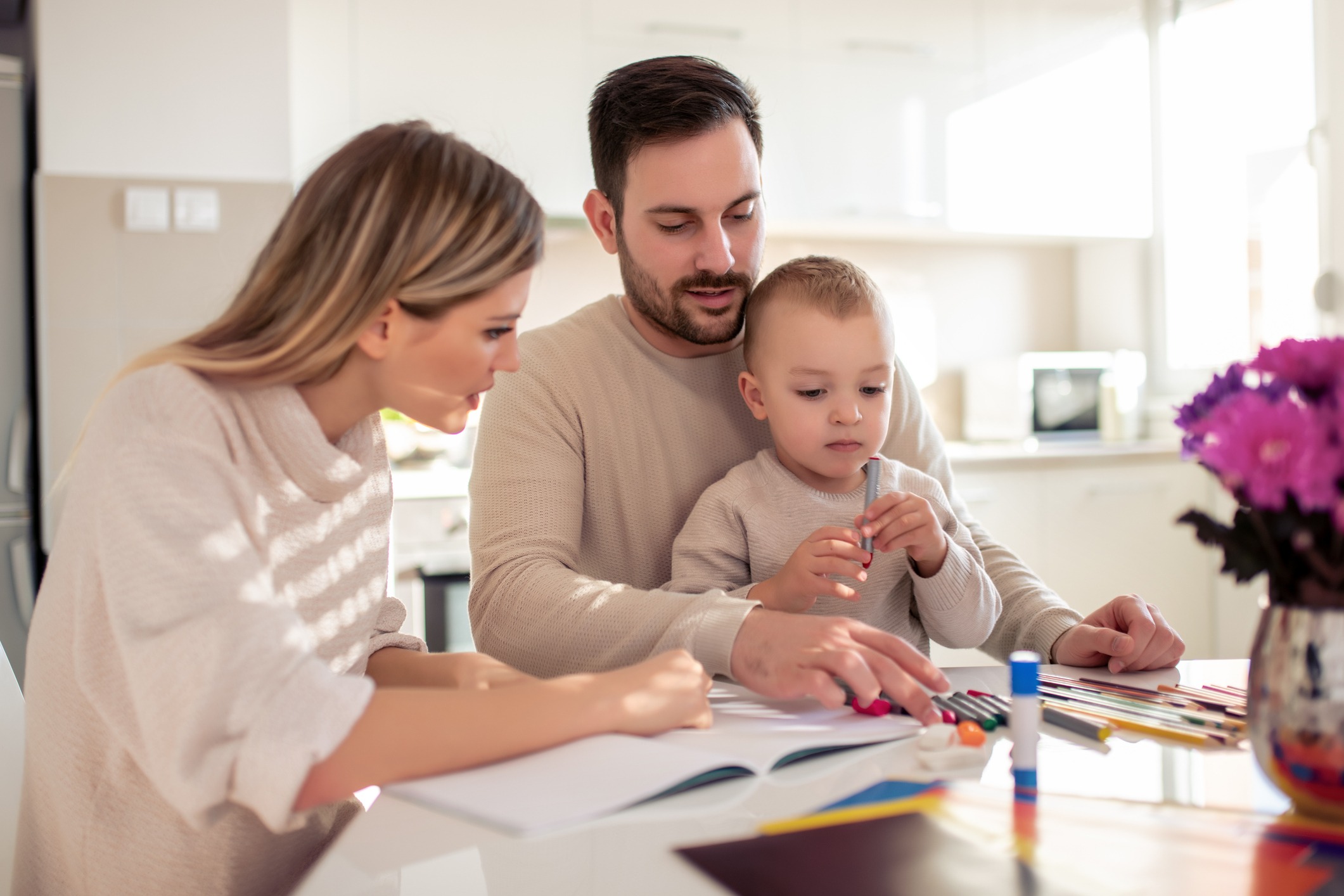 mother and father drawing together with their child