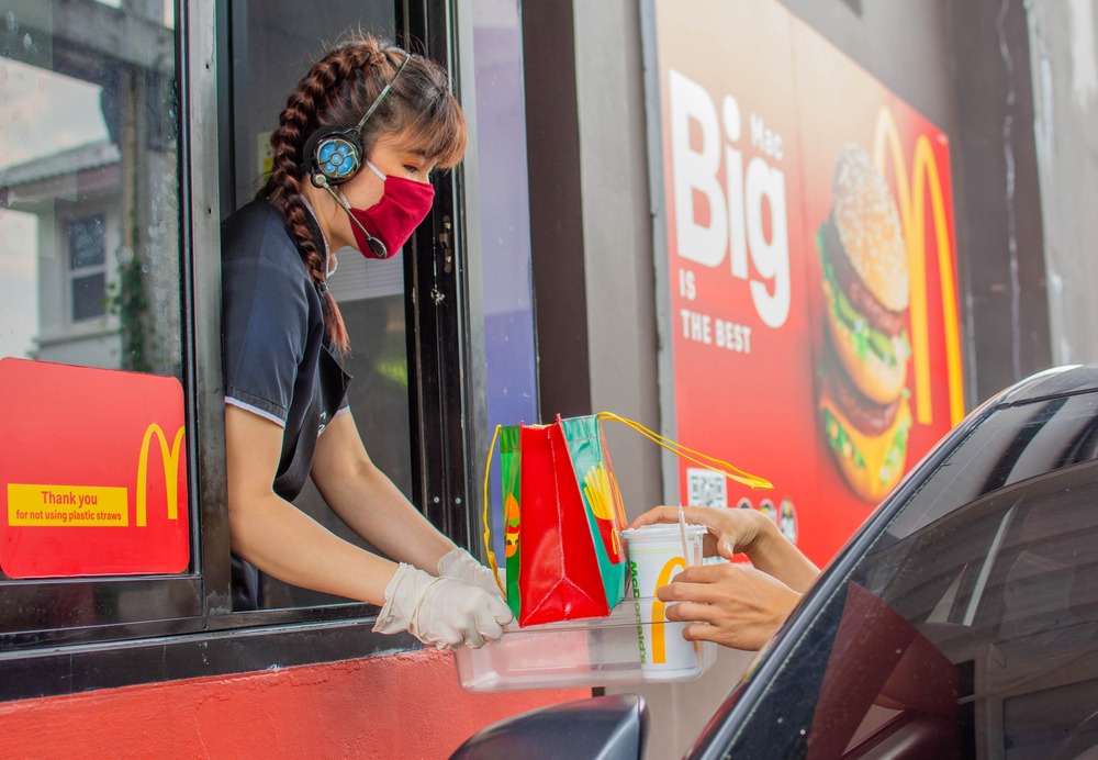 female,staff,at,mcdonald's,deliver,food,to,customers,through,the