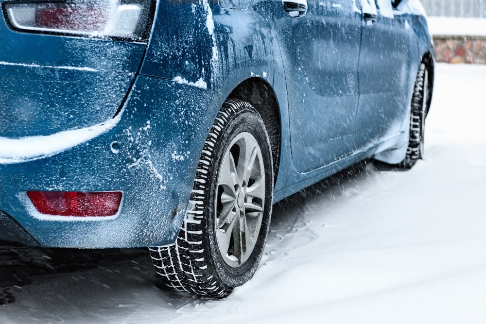 back,view,of,blue,car,covered,with,snow,parked,on