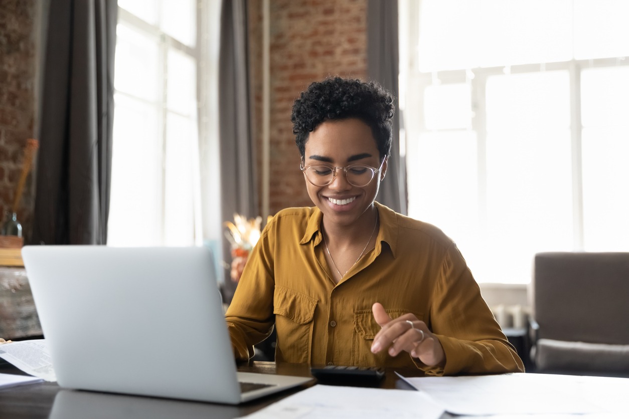 happy young afro american entrepreneur woman in glasses counting profit