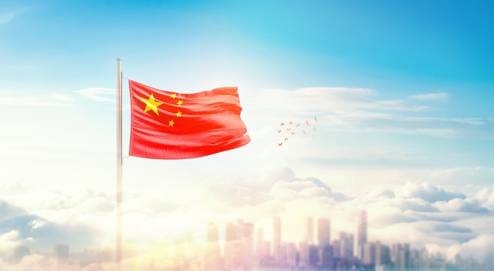 china,flag,wavering,in,beautiful,clouds,with,building,skyline.,the