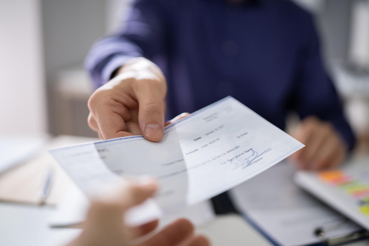 businessperson hands giving cheque